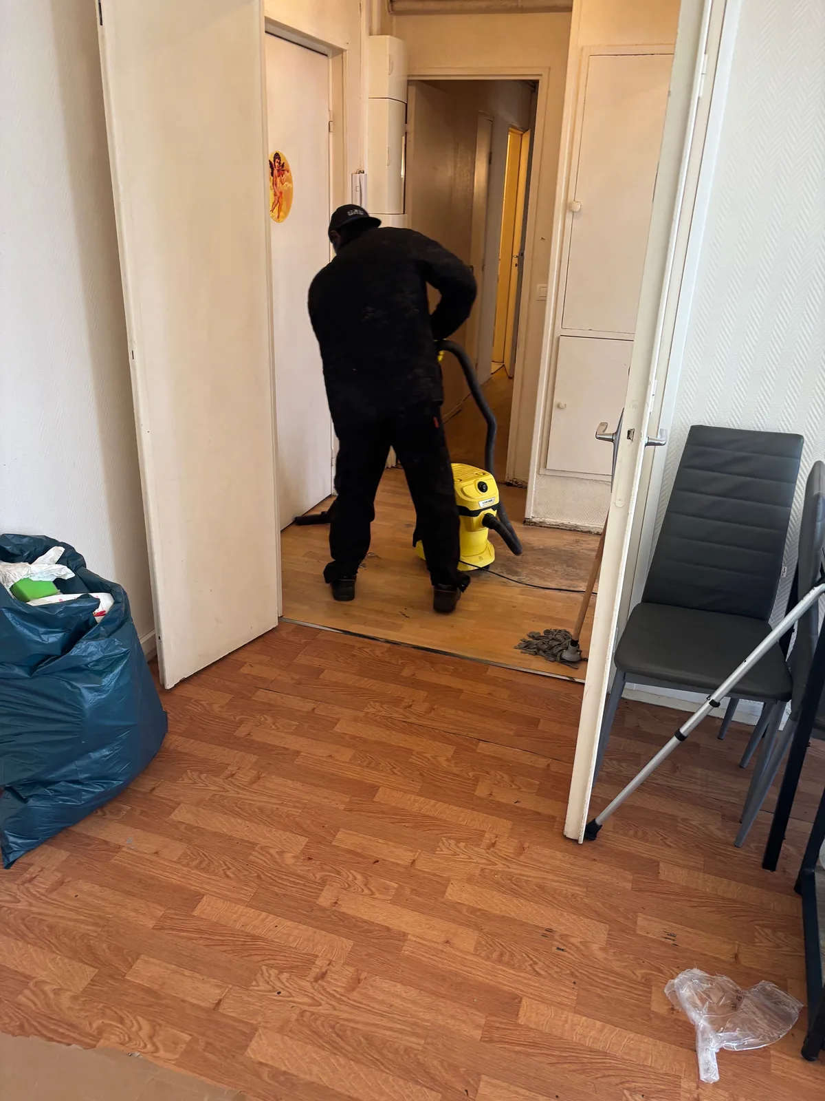 Équipier aspirant le sol après le débarras d’un appartement
