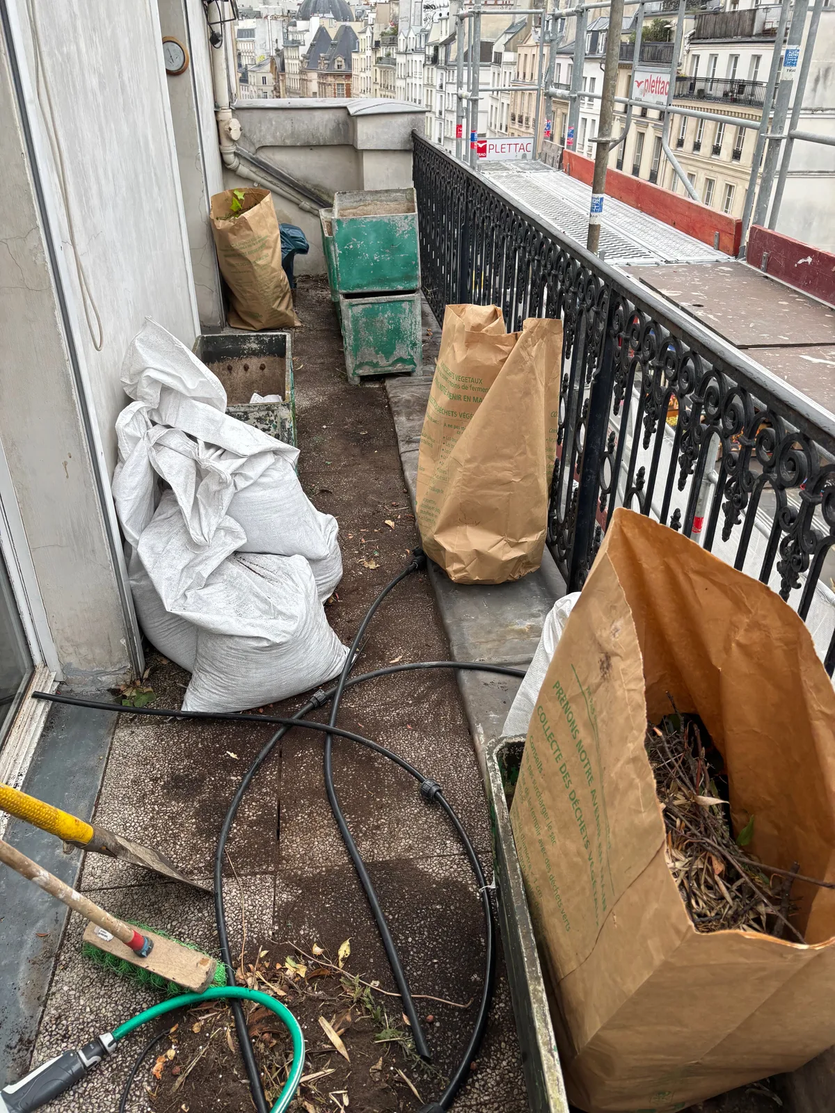 Balcon parisien encombré avant une intervention de débarras