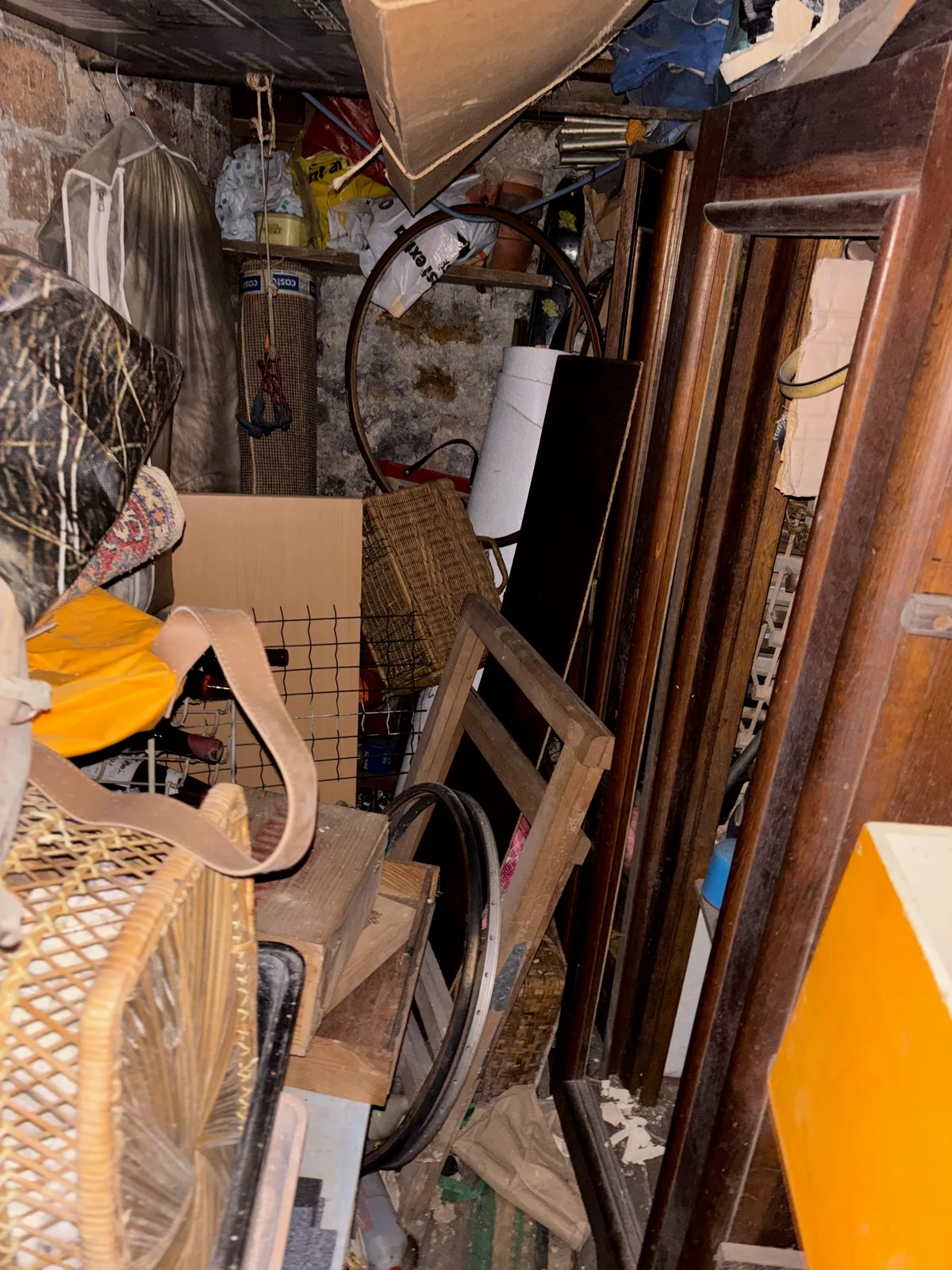Cave encombrée de meubles, cartons et objets à évacuer