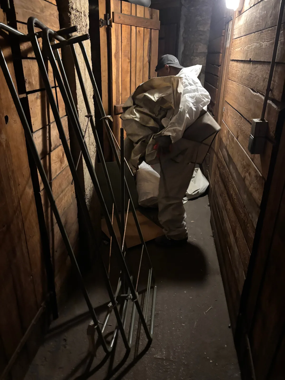 Équipier protégé évacuant des objets dans un passage de cave étroit