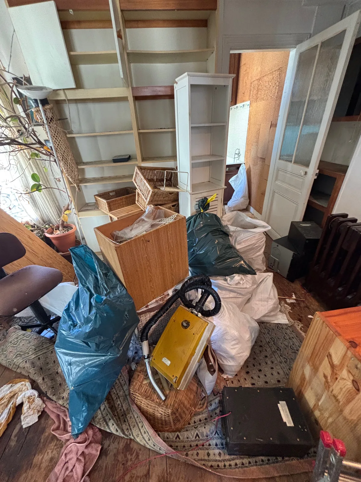 Pièce encombrée avec meubles, sacs et objets à trier